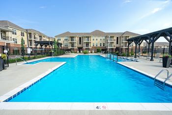 A large swimming pool in front of apartment buildings.